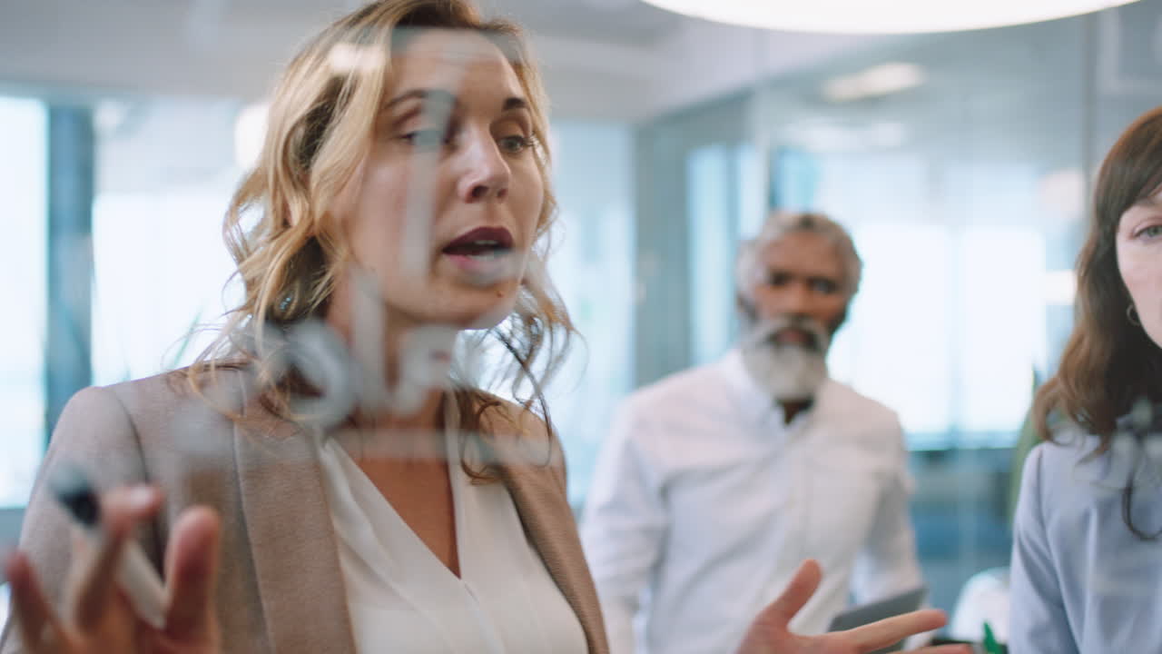 uomini d'affari che usano note adesive brainstorming team leader donna che lavora con i colleghi scrivendo su lavagna di vetro che mostra la strategia di risoluzione dei problemi in riunione in ufficio