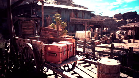 old wooden cart loaded with boxes near rustic structures under blue sky