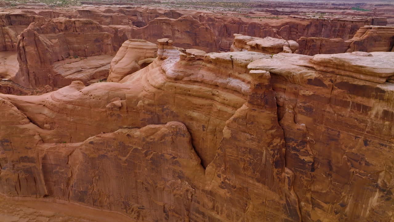 Rounded peaks and tops of orange mountains. Drone footage over the rocks in Arches National Park, Utah, USA.