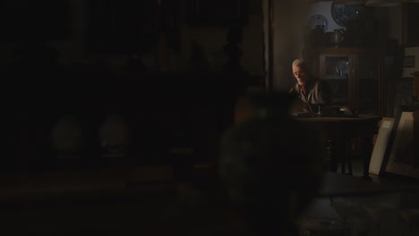 old passionate man read a book in his office at night