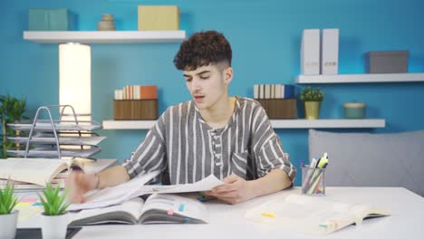 el estudiante que estudia en casa mira los papeles y se deprime.