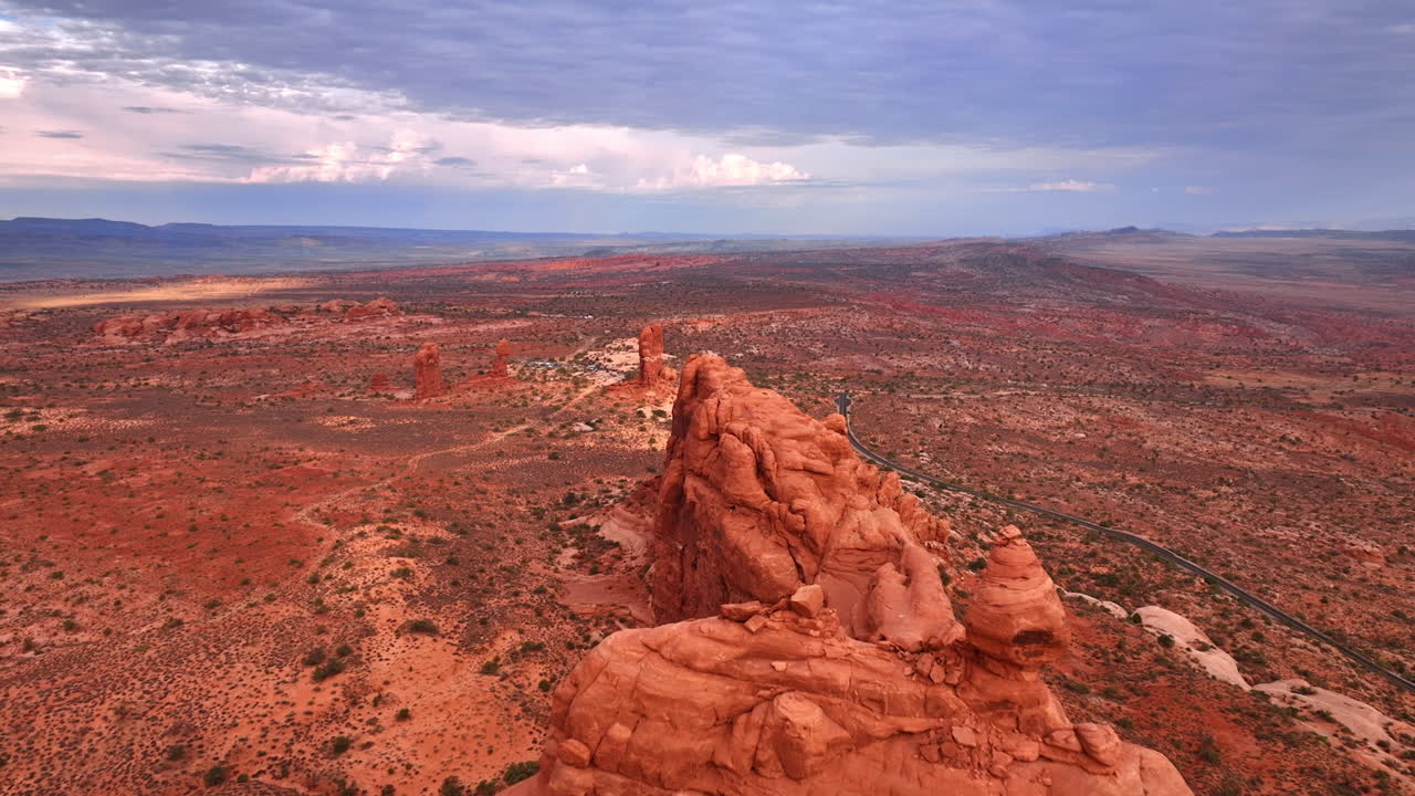Optagelser af de finurligt formede, røde klipper i den tørre ørken. Gråt skydække dækker himlen over landskabet i Arches Nationalpark i Utah, USA.