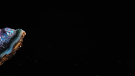 sartén suave y cautivadora a través de un cristal de amatista púrpura iluminado sobre un fondo negro