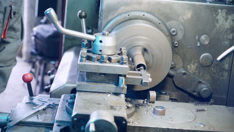 close up hand heavy industrial worker is working on metal work factory process by performing mechanical turning operation at machine for steel structure industry