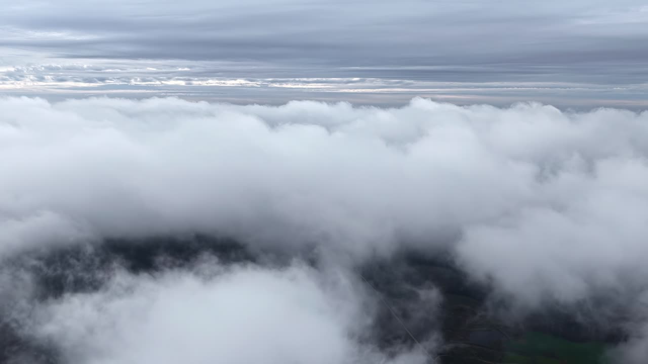 Thick White Clouds Covering the Landscape Beneath a Gray, Overcast Sky - Aerial Drone Shot