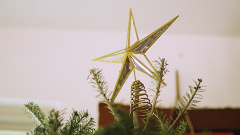 star ornament decoration on top of christmas tree