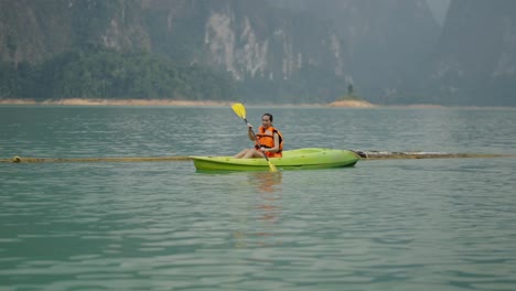 woman kayaking on a serene mountain lake