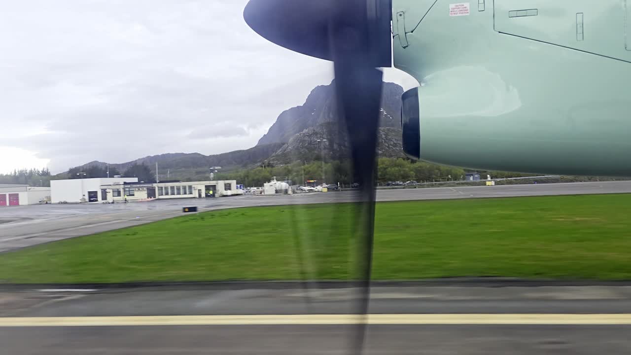 Window view from Wideroe propeller airplane landing over sea with shaking at touchdown in Svolvaer