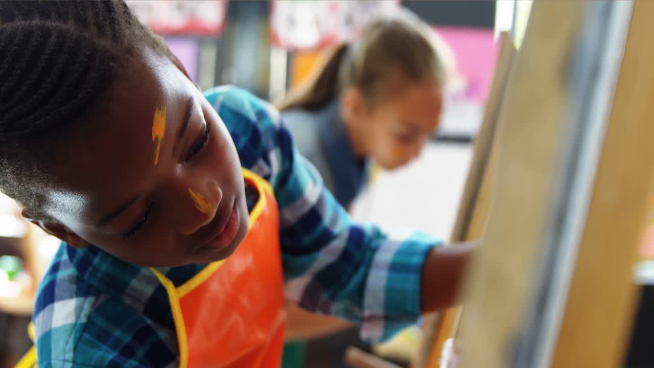 Aandachtige schooljongen schildert op doek