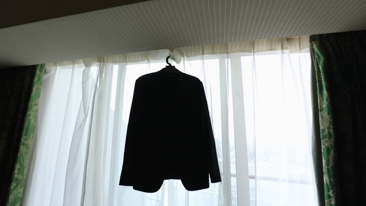 Groom's suit hanging on the window in the morning - push out
