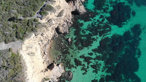 aerial view of beautiful clear turquoise water and rocky cliff