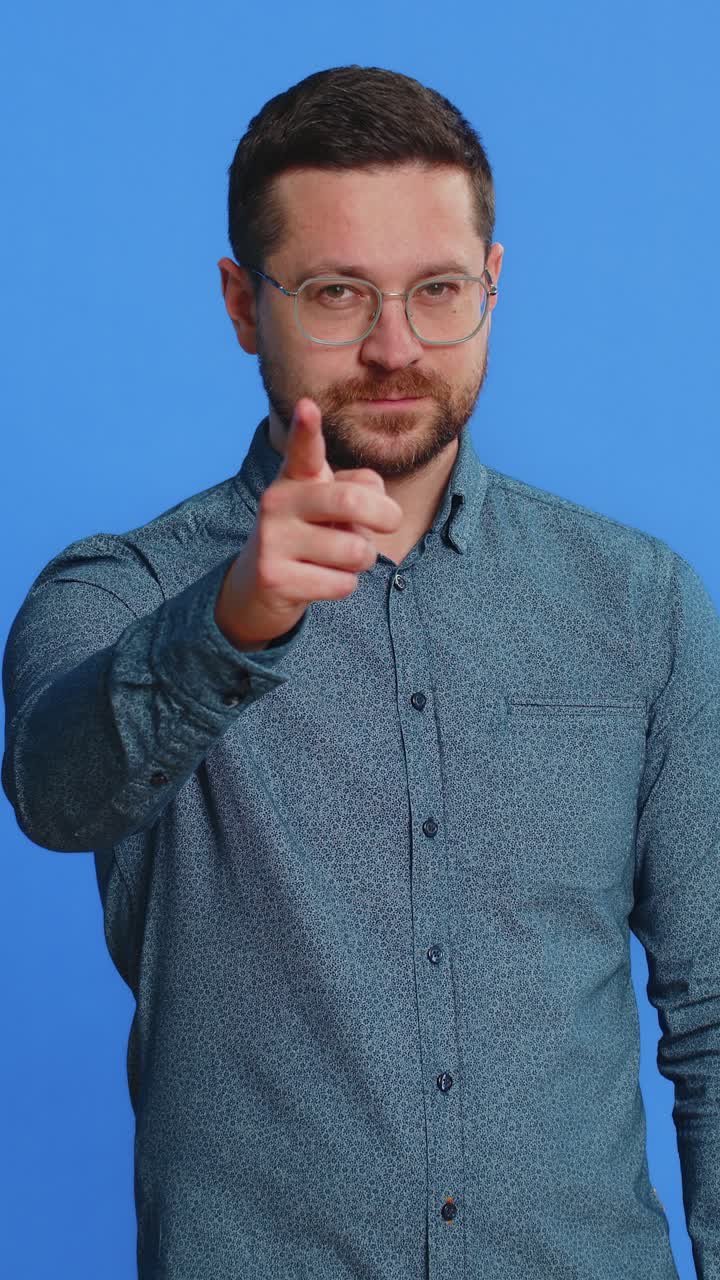 Giovane uomo che indica gli occhi e la fotocamera, a indicare che ti sto osservando, gesto di spiare e osservare qualcuno