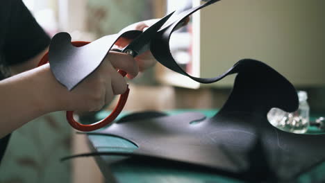 professional worker cuts black leather template making mask