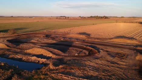 Aerial-view-of-a-sunset-in-a-motocross-racetrack-with-some-riders-in-it