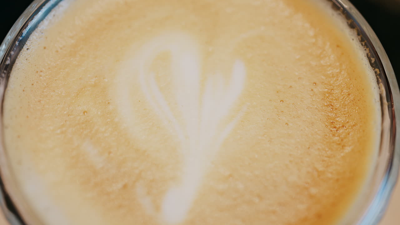 Close up of a glass cup with a latte at a cafe