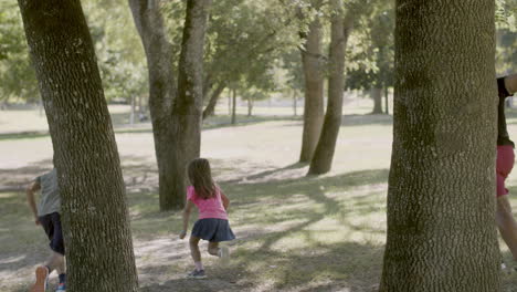 long shot of family playing hide-and-seek in nature