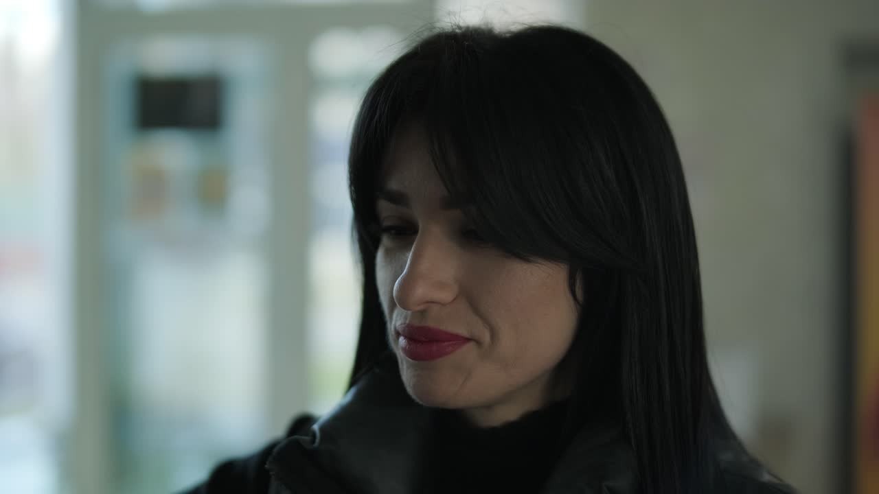 gerente femenina profesional en un traje formal negro, caminando por la oficina, interactuando con colegas, sosteniendo documentos y una computadora portátil, mostrando liderazgo y profesionalismo