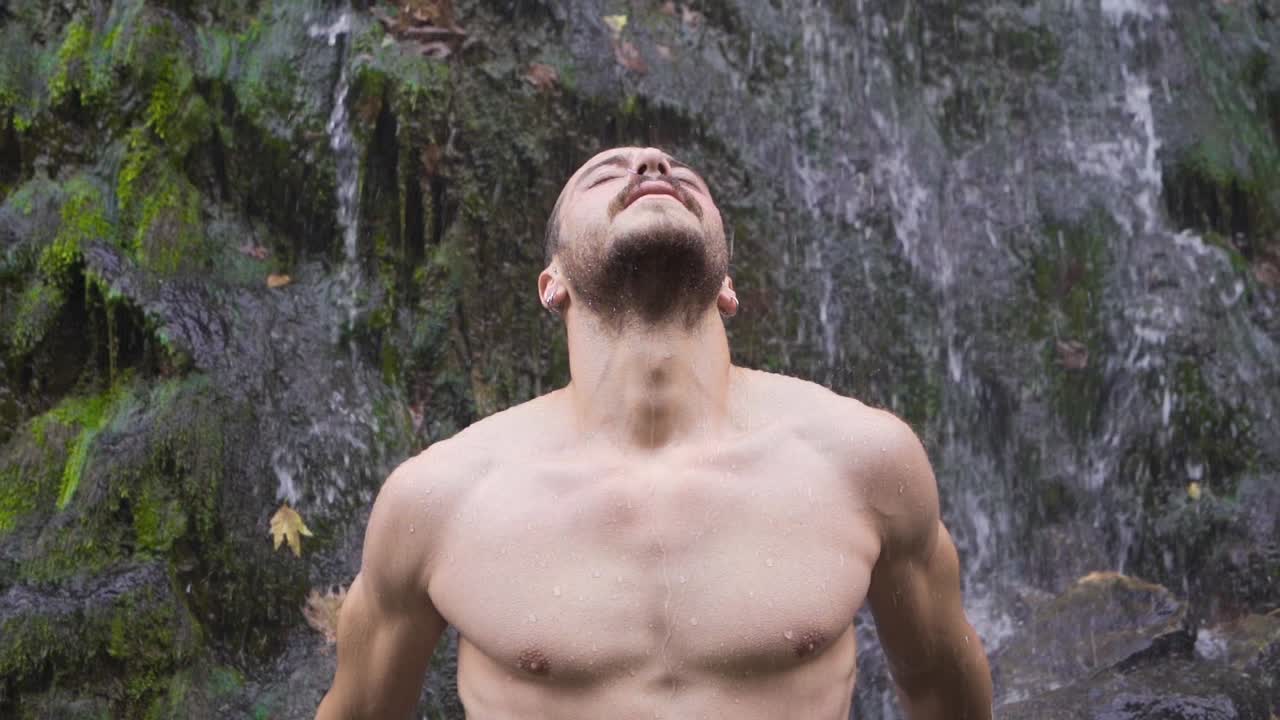 폭포  ⁇ 에 눈을 감고 있는 남자. 평화롭다.