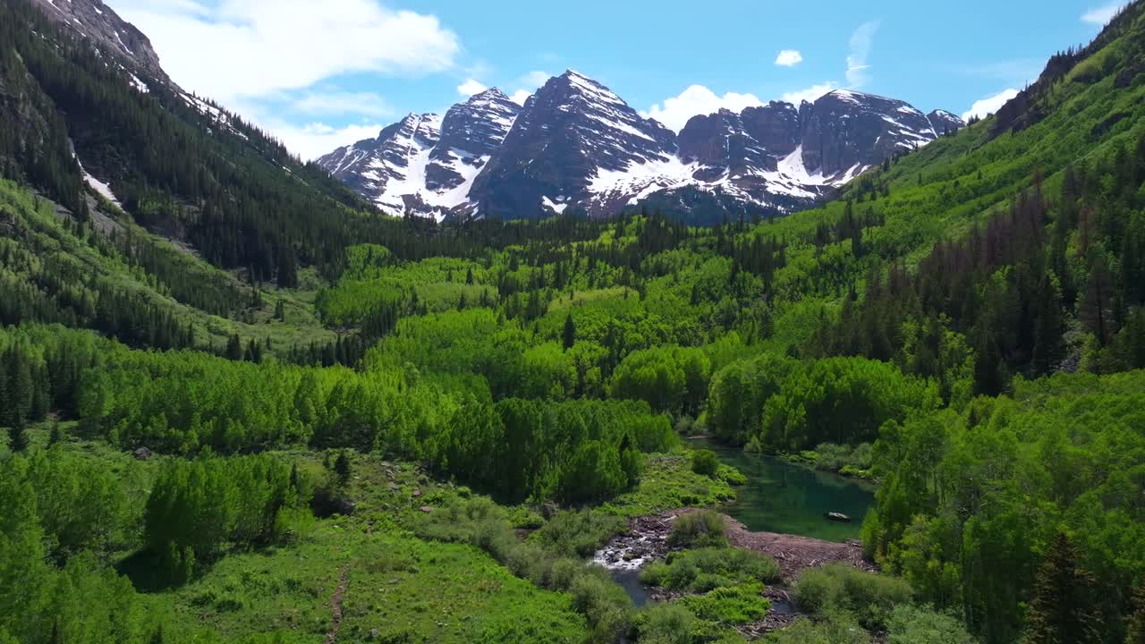 Spring summer Maroon Bells Creek 14er Wilderness aerial drone Colorado morning sunny blue sky Aspen Snowmass Crater Maroon Lake Trees White River National Forest Elk Range Rocky Mountains circle right