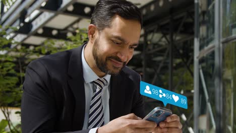 businessman sitting outside city offices looking at mobile phone with motion graphics showing multiple networking messaging and social media notifications 1