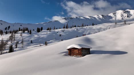 Two-ski-tourers-passing-an-old-hut-on-the-ascent