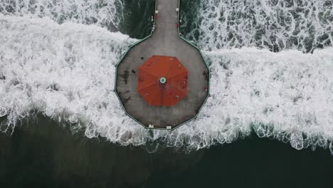 california historical landmark called roundhouse aquarium at the end of the pier at manhattan beach and visitors, view down from the drone