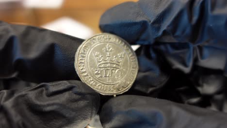 collector examining portuguese gold coin from the medieval age