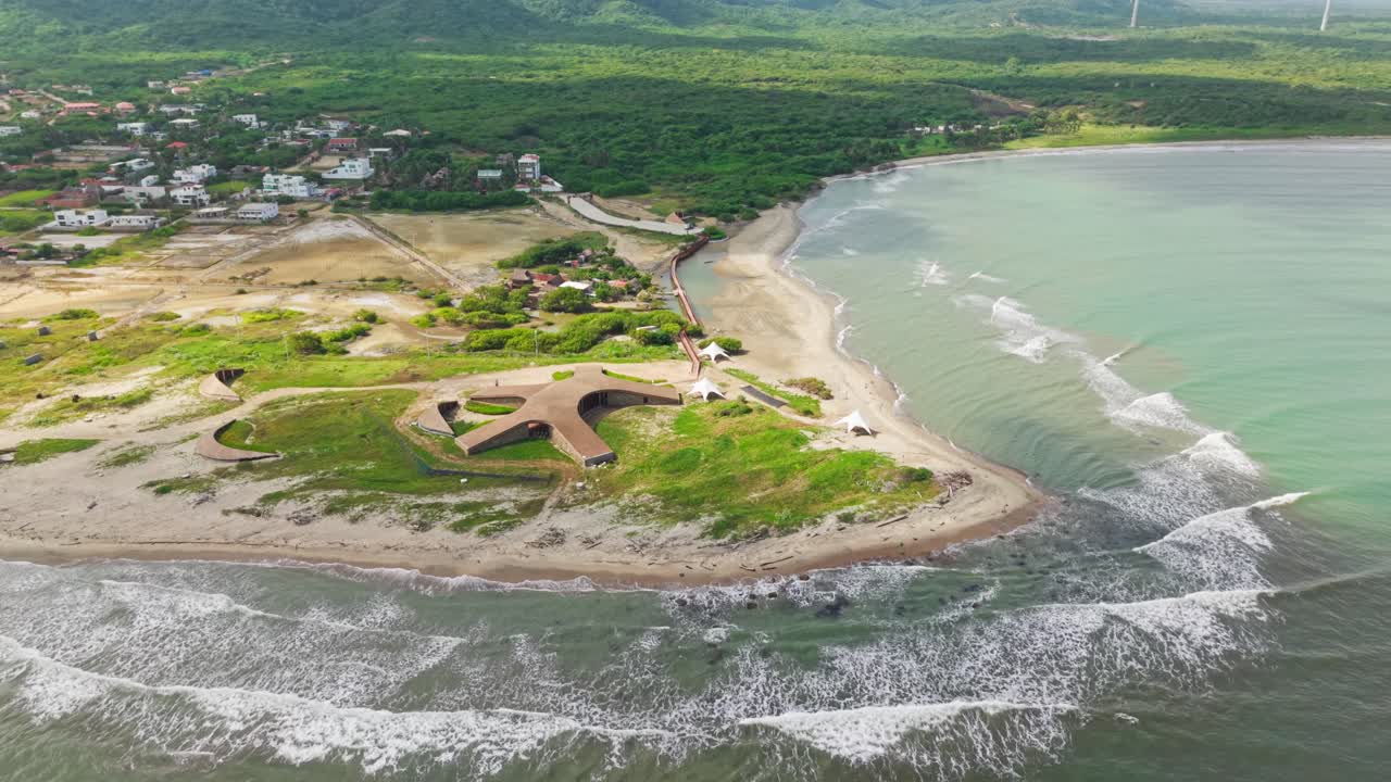 Breathtaking slow-motion aerial perspective showcases a unique architectural gem nestled on a picturesque coastline