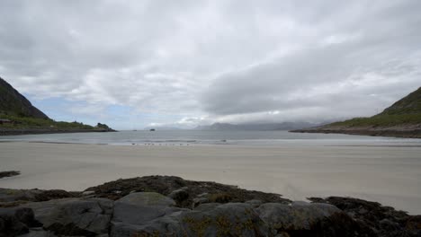 waves roll gently on rorvikstranda as spring clouds sweep across the sky in fast timelapse