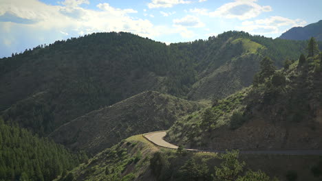 one skateboarder guy bombing a steep hill in colorado backcountry on a skateboard