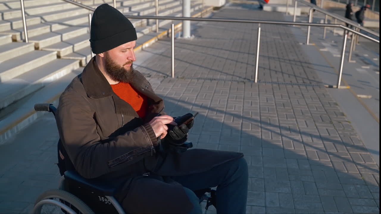 Man in Wheelchair Using Smartphone