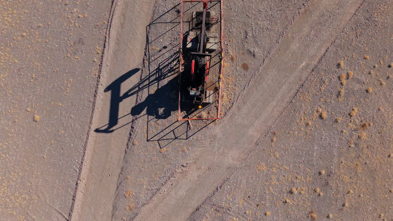 Aerial top-down shot of a pumpjack extracting oil in the dry lands of Mendoza, Argentina