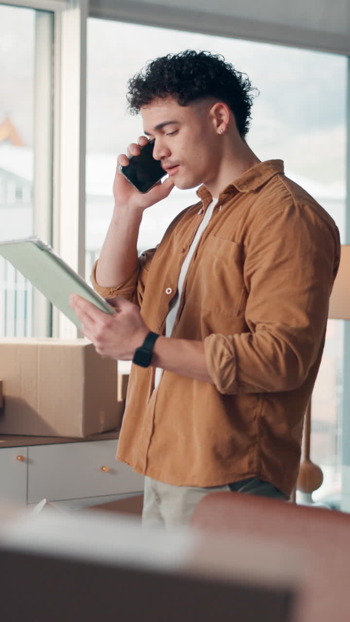 Young Man Talking on Phone and Checking Documents in Home Office