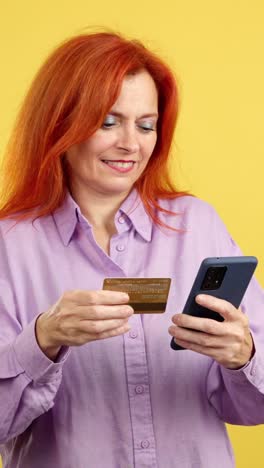 woman smiling while making an online payment with a credit card and smartphone
