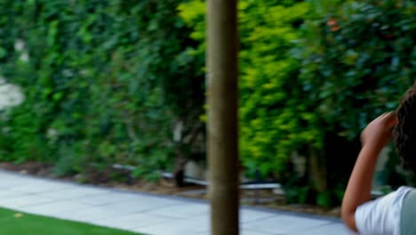 Side-view-of-black-young-family-having-fun-in-back-yard-of-their-home-4k