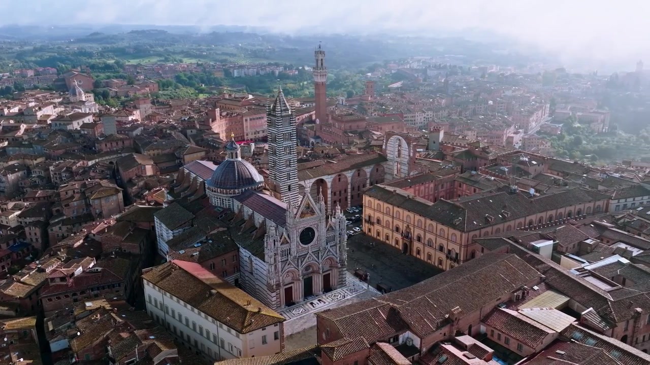 Vista aerea del Duomo di Siena a Siena, Provincia di Siena, Italia. La Torre del Mangia è sullo sfondo. Orbita di tracciamento del drone.