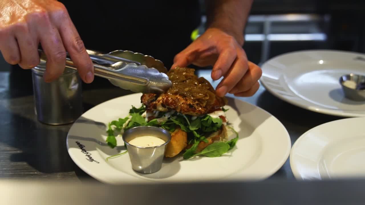 chef emplatando carne en un plato en la cocina