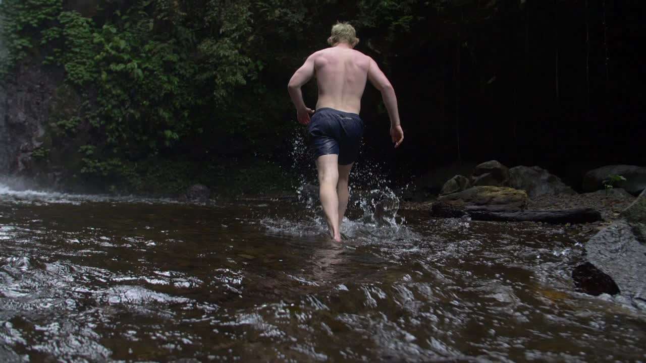 삼림 개울을 걷는 남자