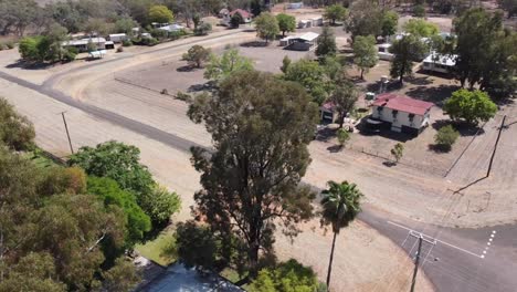 drone volando sobre árboles y casas en un pequeño pueblo de campo en el interior de australia