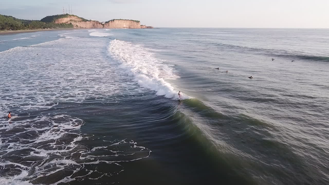 surfista montando las olas con impresionantes aguas oceánicas en la playa de olon, ecuador durante el verano