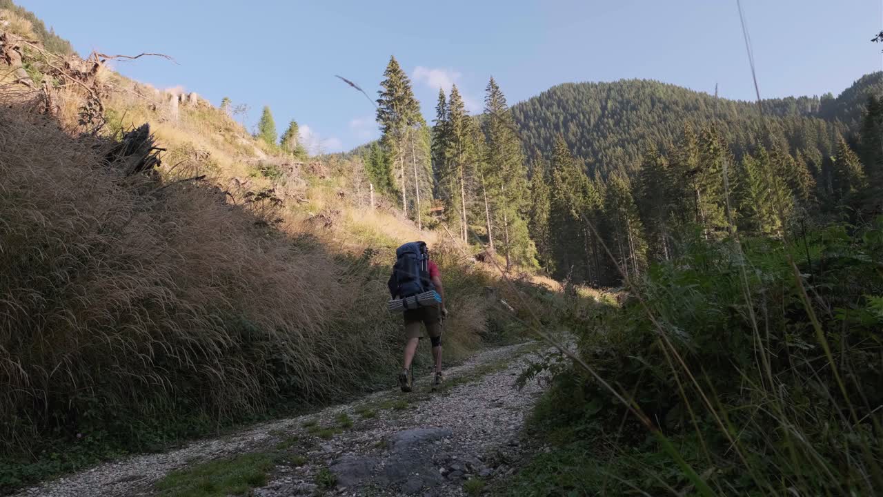 화창한 날 이탈리아의 산 가장자리까지 돌이 많은 트레일을 걷는 등산객의 뒷모습