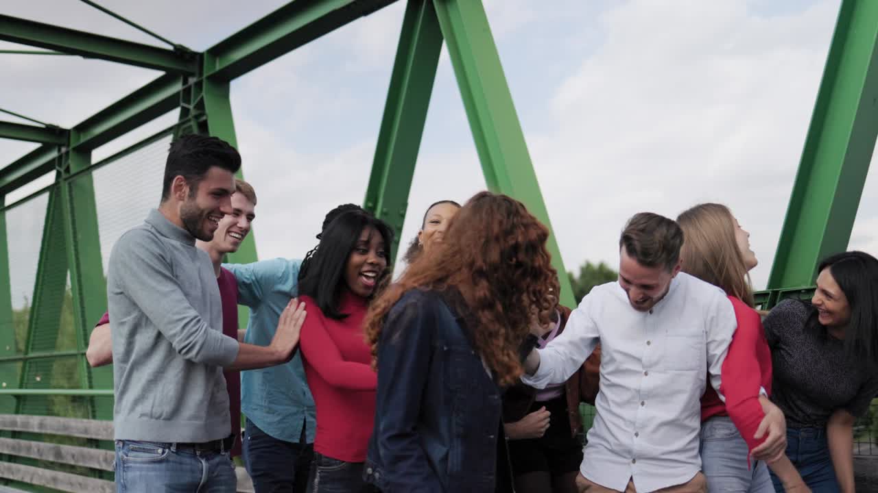 grupo multiétnico de amigos divirtiéndose caminando por el parque del puente al aire libre