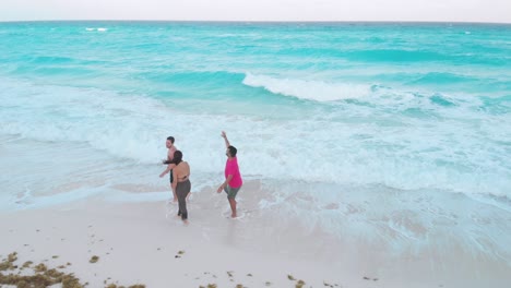 vacationing travelers relaxing and walking on pristine white sand beach, enjoying crystal clear turquoise waters in scenic hotel zone of cancun, quintana roo, mexico