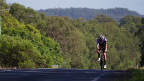 Athletenradfahrer,-Der-Auf-Einer-Von-Bäumen-Umgebenen-Straße-Bergauf-Fährt,-4k