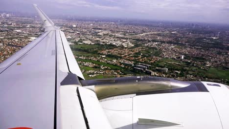 incredible aerial view of jakarta cityscape over the wing of an airplane