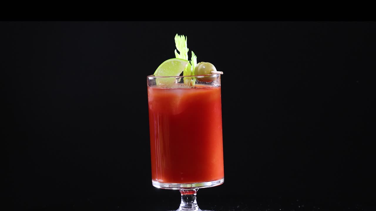 A series of Bloody Mary cocktails with garnishes against a dark backdrop, highlighting vibrant colors and elegant presentation