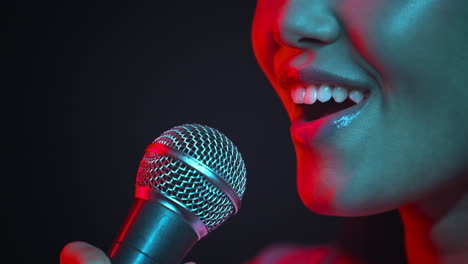 woman singing into microphone in neon lights