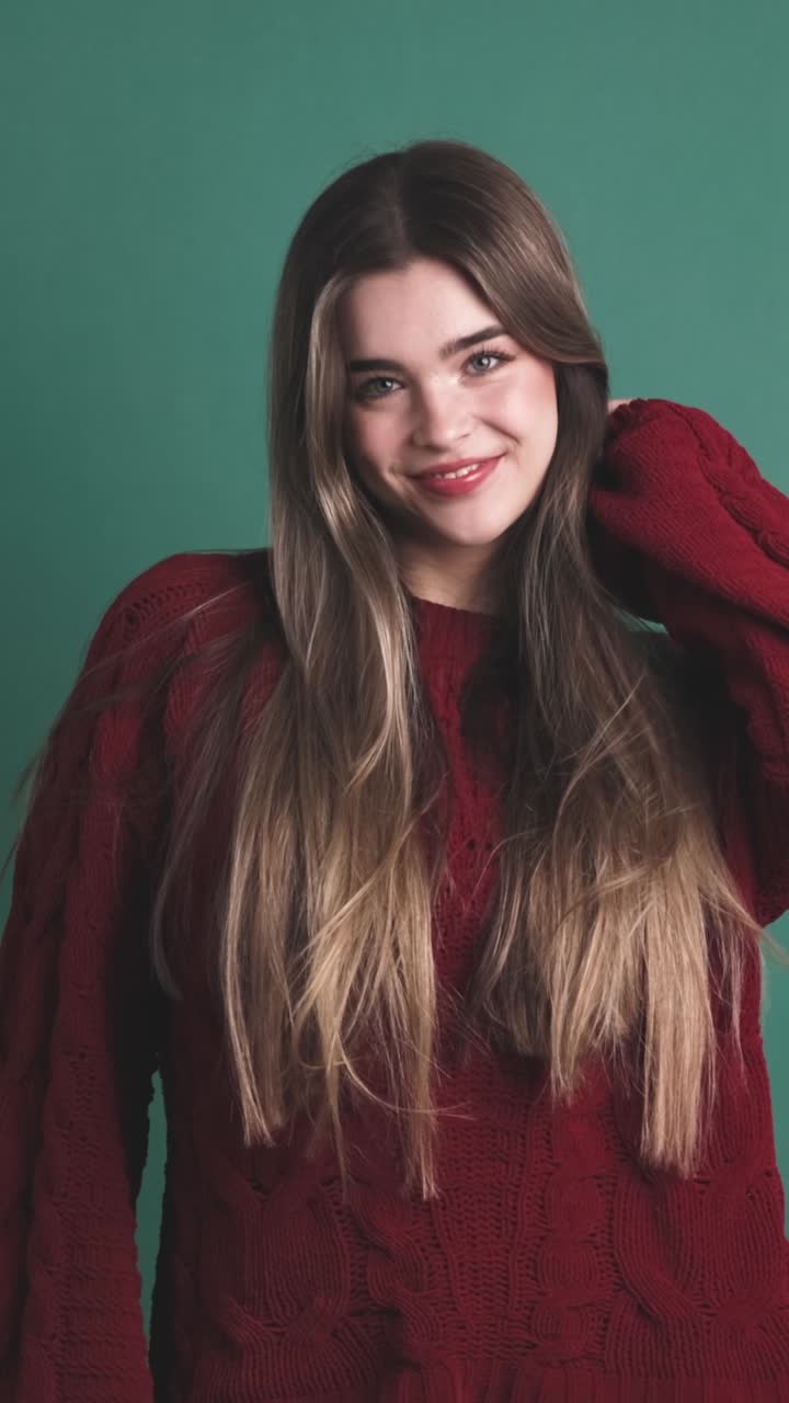 beauty young woman smiling at camera in studio with green background