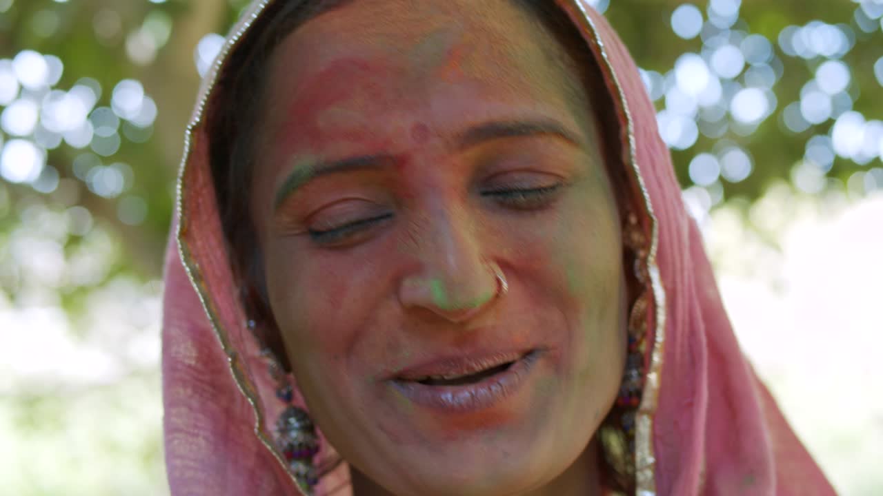 mujeres indias de primer plano de la cara manchada con colores brillantes de holi