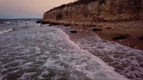 hermosas olas en la playa golpeando las rocas al atardecer